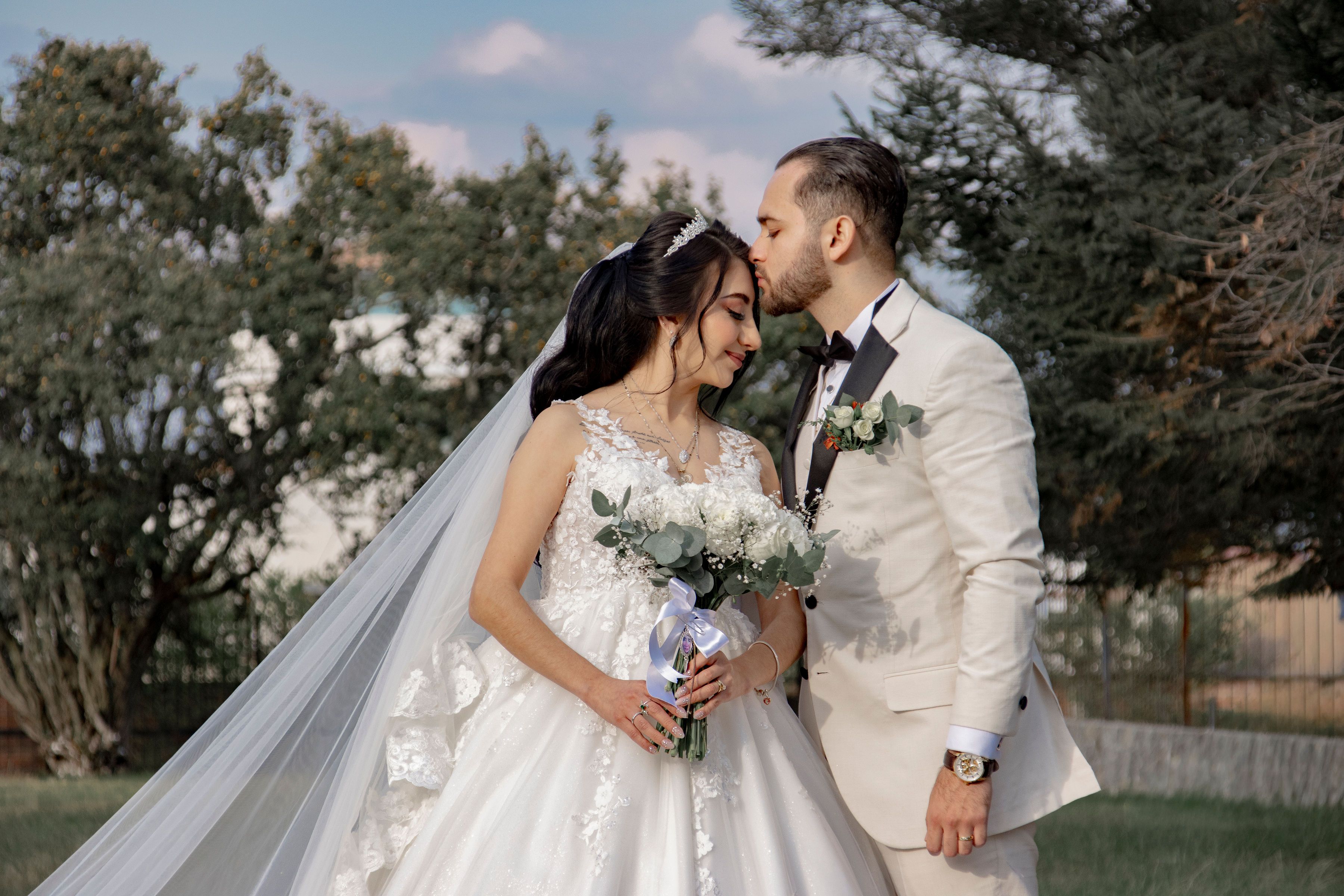 Amara and Theo laughing as guests throw petals after their garden ceremony