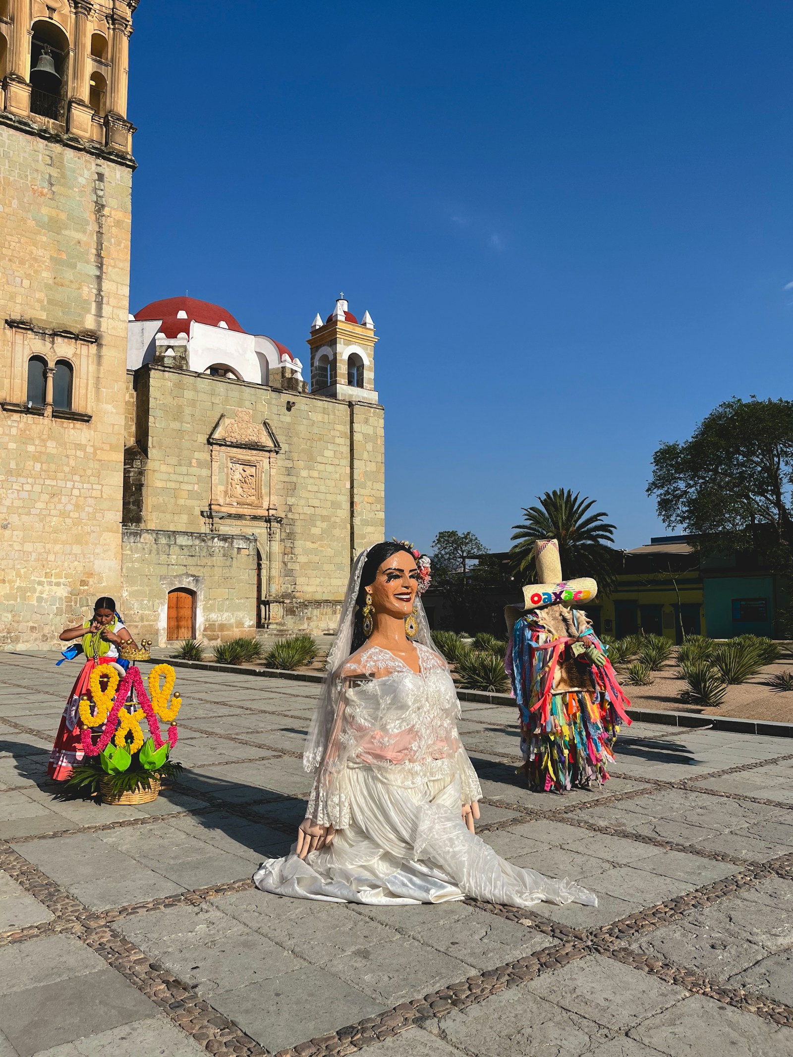 Wedding figures and flower displays outside a historic stone church